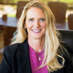 A white lady in her 40's smiling.